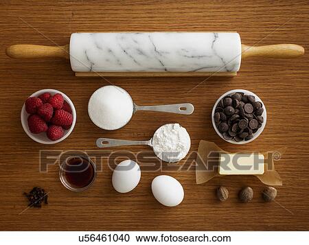 Stock Image - Studio shot of wooden table with rolling pin and fresh ingredients. Fotosearch
