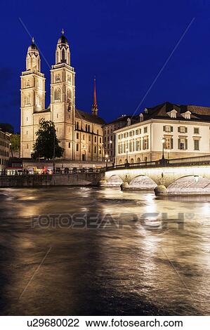 Stock Image - Switzerland, Zurich, Grossmunster Church and Limmat River at night. Fotosearch