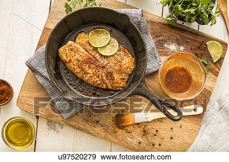 Stock Photo - Tilapia on frying pan. Fotosearch