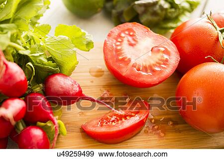 Stock Photo - Tomato and radish on cutting board. Fotosearch