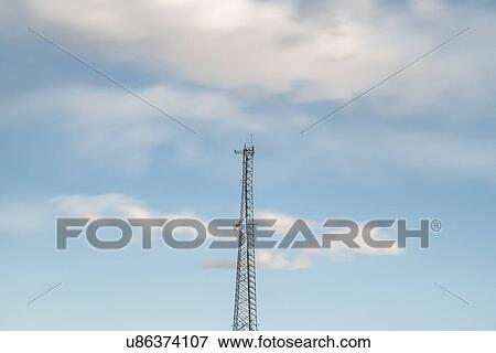 Stock Photo - Top of communications tower with sky and clouds in background. Fotosearch