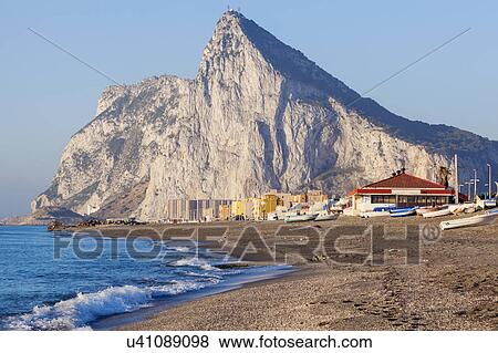 Stock Photo - UK, Rock of Gibraltar with sandy beach in foreground. Fotosearch