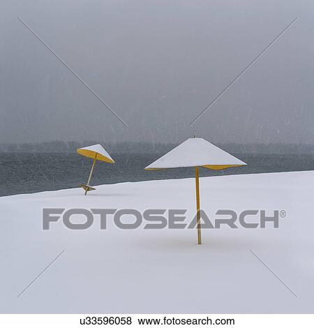 Stock Photo - Ukraine, Dnepropetrovsk Region, Dnepropetrovsk city, Snowy beach with sunshades. Fotosearch