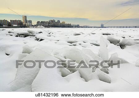 Stock Photograph - Ukraine, Dnepropetrovsk region, Dnepropetrovsk city, Frozen river with distant cityscape. Fotosearch