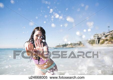 Stock Photography - USA, California, Woman playing in water on Laguna Beach. Fotosearch
