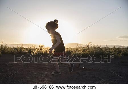 USA, Colorado, Little girl (4-5) running on dirt road at sunset View Large Photo Image Stock Photograph - USA, Colorado, Little girl (4-5) running on dirt road at sunset. Fotosearch