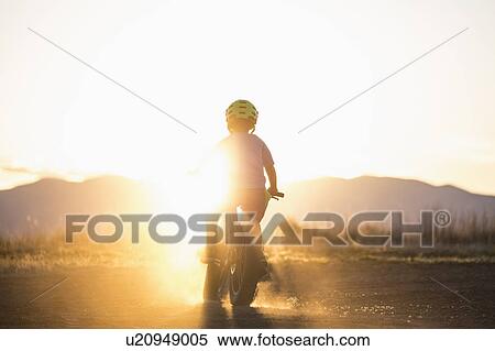 USA, Colorado, Rear view of boy (8-9) cycling at sunset View Large Photo Image Stock Photography - USA, Colorado, Rear view of boy (8-9) cycling at sunset. Fotosearch