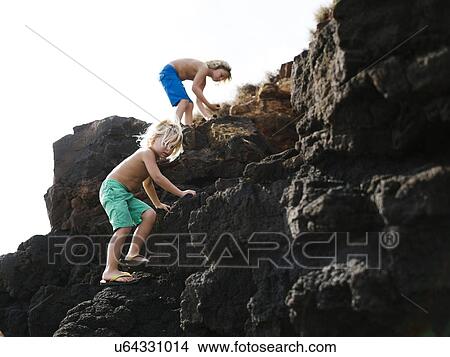 USA, Hawaii, Kauai, Boys (4-5, 8-9) climbing on rocks View Large Photo Image Picture - USA, Hawaii, Kauai, Boys (4-5, 8-9) climbing on rocks. Fotosearch