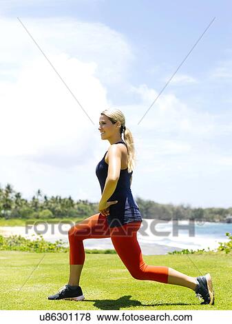 Stock Photo - USA, Hawaii, Kauai, Woman exercising on beach. Fotosearch