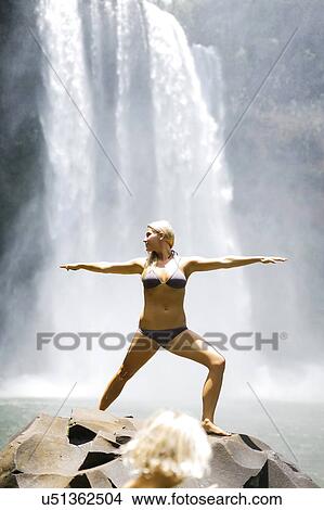 Picture - USA, Hawaii, Kauai, Woman practicing yoga next to waterfall. Fotosearch