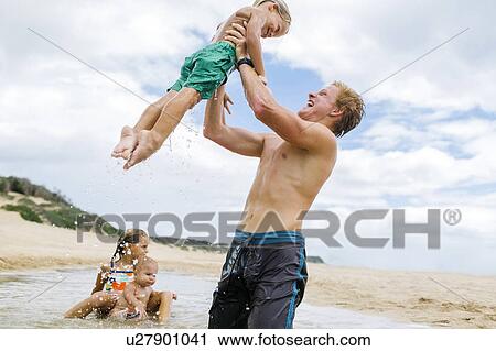 USA, Hawaii, Kauai, Young man with three younger siblings (12-17 months, 4-5, 6-7) playing at beach View Large Photo Image Stock Image - USA, Hawaii, Kauai, Young man with three younger siblings (12-17 months, 4-5, 6-7) playing at beach. Fotosearch