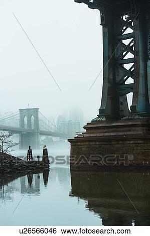 Stock Photograph - USA, New York, New York City, Manhattan, Brooklyn Bridge over East River in fog. Fotosearch