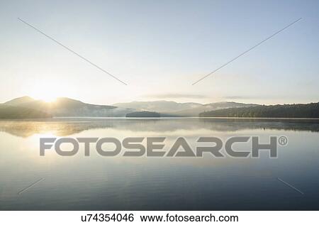 Stock Photograph - USA, New York, St. Armand, Lake Placid at sunrise. Fotosearch