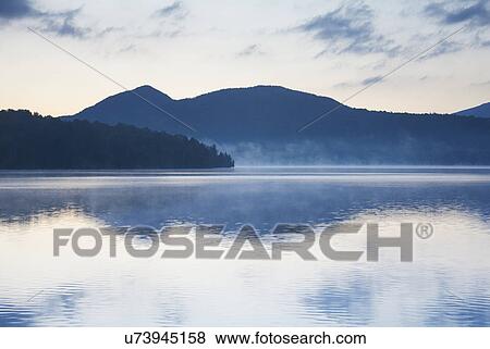 Stock Photo - USA, New York, St. Armand, Sunrise over Lake Placid. Fotosearch