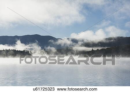 Stock Image - USA, New York State, Fog above Lake Placid. Fotosearch