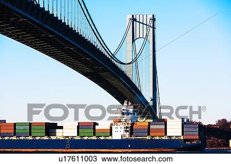 Stock Image - USA, New York State, New York City, Cargo ship under verrazano narrows bridge. Fotosearch