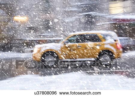 Stock Photograph - USA, New York State, New York City, Yellow cab driving during snowstorm. Fotosearch
