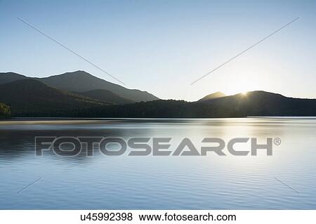 Stock Photo - USA, New York State, St Armand, Lake Placid at sunrise. Fotosearch