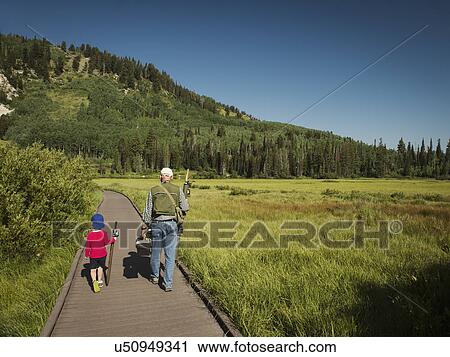 USA, Utah, Lake City, Boy (4-5) with grandfather walking on boardwalk through wetland View Large Photo Image Stock Image - USA, Utah, Lake City, Boy (4-5) with grandfather walking on boardwalk through wetland. Fotosearch