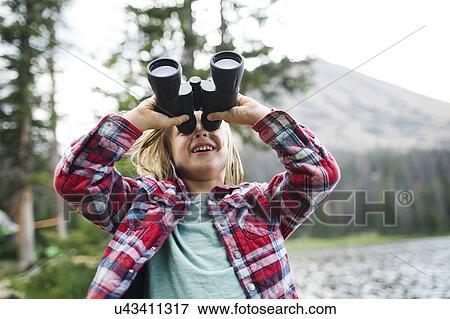 Stock Photo - USA, Utah, Midway, Portrait of boy (6-7) looking through binoculars. Fotosearch