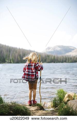 Stock Photo - USA, Utah, Midway, Rear view of boy (6-7) standing by lake. Fotosearch