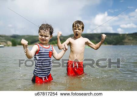 USA, Utah, Park City, Brothers (4-5, 6-7) flexing muscles while wading in lake View Large Photo Image Picture - USA, Utah, Park City, Brothers (4-5, 6-7) flexing muscles while wading in lake. Fotosearch