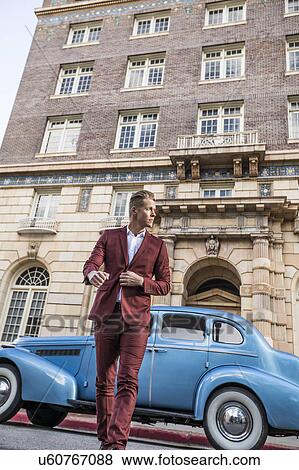 Stock Photo - USA, Utah, Salt Lake city, Elegant man crossing street, vintage car in background. Fotosearch