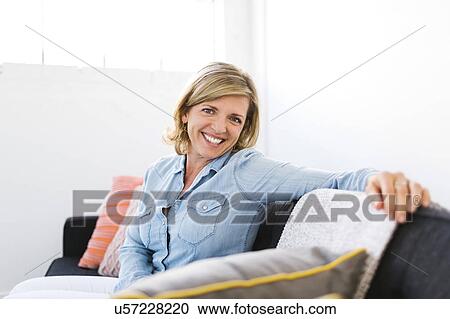 USA, Utah, Salt Lake City, Portrait of happy Mature woman sitting on sofa View Large Photo Image Stock Image - USA, Utah, Salt Lake City, Portrait of happy Mature woman sitting on sofa. Fotosearch