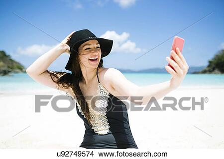 USA, Virgin Islands, Saint Thomas, Woman doing selfie on beach at sunny day View Large Photo Image Picture - USA, Virgin Islands, Saint Thomas, Woman doing selfie on beach at sunny day. Fotosearch