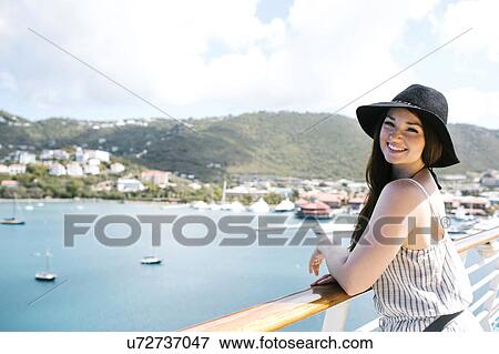 Stock Photo - USA, Virgin Islands, Saint Thomas, Woman leaning against railing and looking at bay. Fotosearch