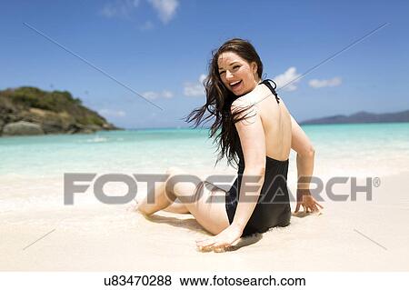 Stock Photo - USA, Virgin Islands, Saint Thomas, Beautiful woman sitting on shore. Fotosearch