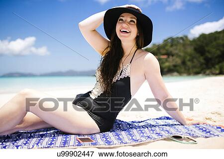 USA, Virgin Islands, Saint Thomas, Cheerful woman sitting on towel on beach View Large Photo Image Stock Photo - USA, Virgin Islands, Saint Thomas, Cheerful woman sitting on towel on beach. Fotosearch