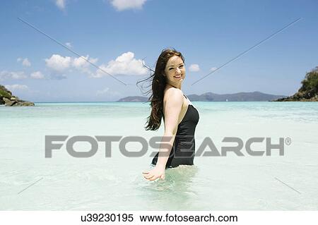 Stock Photography - USA, Virgin Islands, Saint Thomas, Beautiful woman standing in ocean. Fotosearch