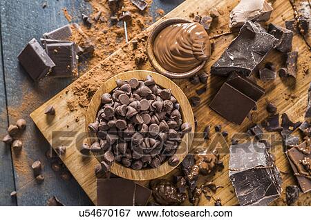 Stock Photo - Various chocolate pieces and melted chocolate on cutting board. Fotosearch