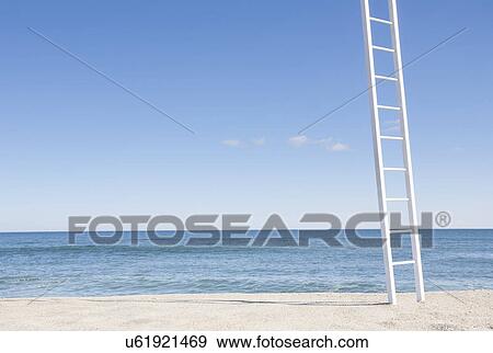 Stock Photo - White ladder on empty beach with blue ocean in background. Fotosearch
