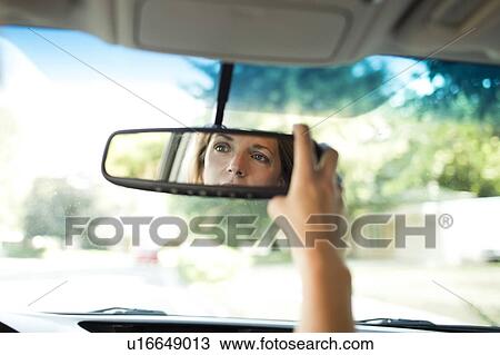 Woman adjusting rear-view mirror in car View Large Photo Image Stock Image - Woman adjusting rear-view mirror in car. Fotosearch