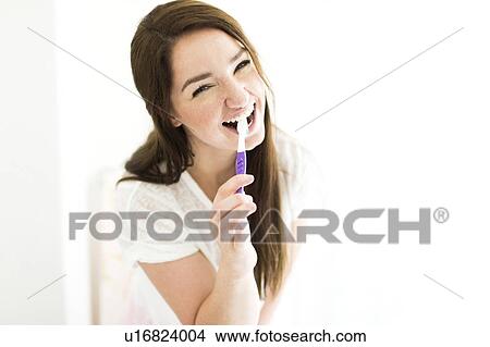 Woman brushing teeth and smiling View Large Photo Image Picture - Woman brushing teeth and smiling. Fotosearch