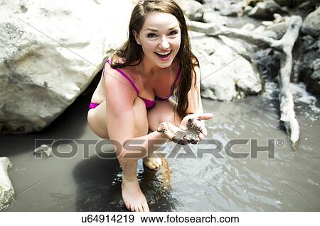 Woman crouching in small pond View Large Photo Image Stock Photo - Woman crouching in small pond. Fotosearch