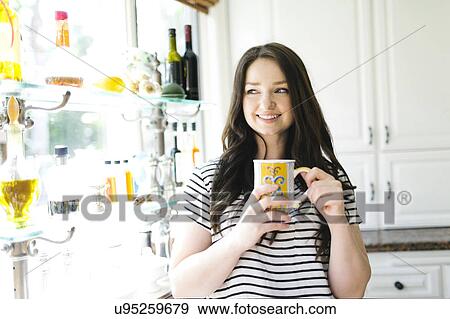 Woman drinking coffee at home View Large Photo Image Stock Photo - Woman drinking coffee at home. Fotosearch