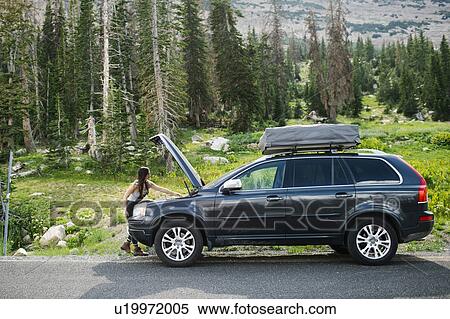 Stock Photography - Woman experiencing car problems during trip. Fotosearch