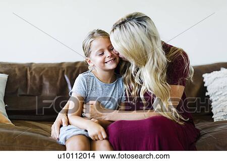 Woman giving daughter (6-7) cheek kiss View Large Photo Image Picture - Woman giving daughter (6-7) cheek kiss. Fotosearch