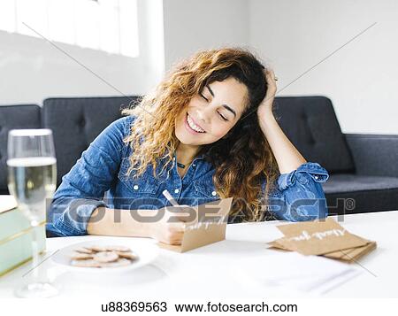 Stock Image - Woman handwriting in living room. Fotosearch