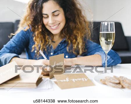 Stock Photo - Woman handwriting in living room. Fotosearch