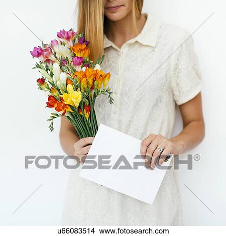 Picture - Woman holding bouquet and letter. Fotosearch