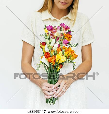 Stock Photo - Woman holding bouquet of freesias. Fotosearch