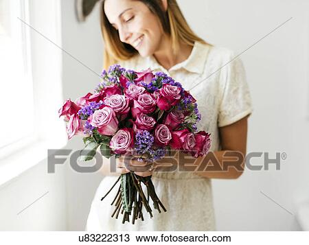 Stock Image - Woman holding bouquet of roses. Fotosearch
