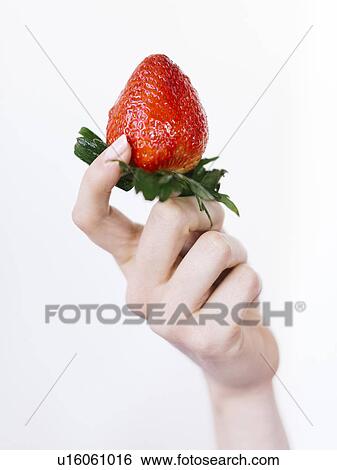 Stock Photograph - Woman holding fresh strawberry. Fotosearch