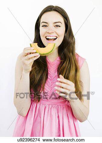 Woman in pink dress eating fruit View Large Photo Image Picture - Woman in pink dress eating fruit. Fotosearch
