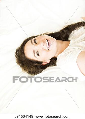 Woman lying on bed and smiling View Large Photo Image Stock Photo - Woman lying on bed and smiling. Fotosearch