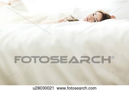 Woman lying on bed View Large Photo Image Stock Image - Woman lying on bed. Fotosearch